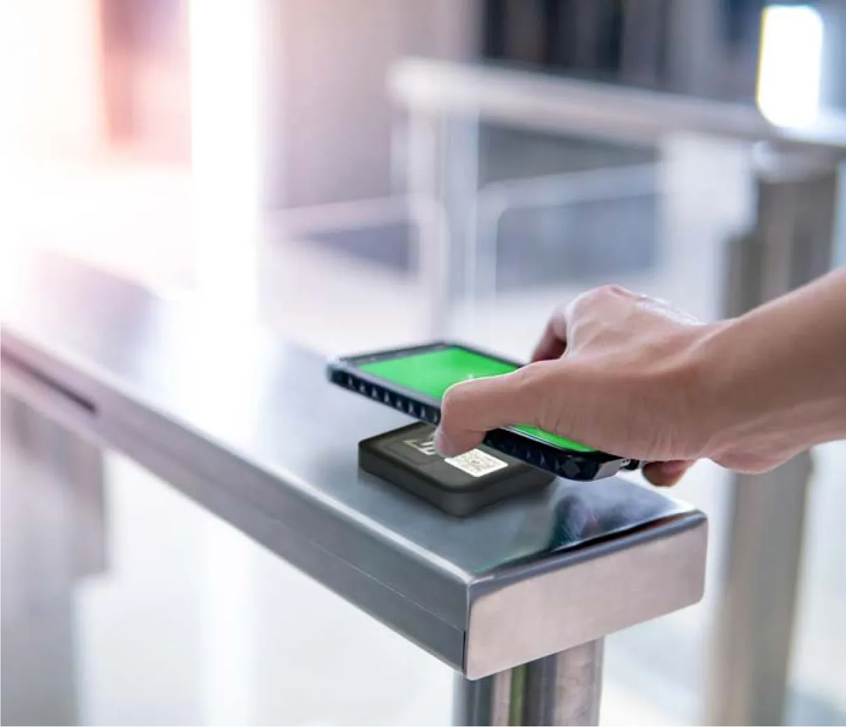 A phone held to an access reader on a turnstile